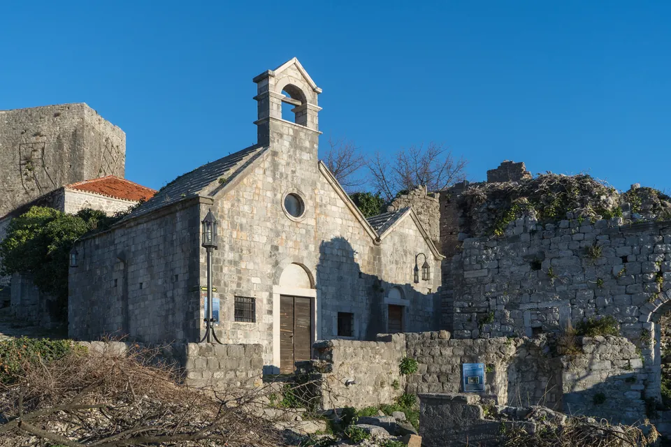 Stone church with a bell tower standing among the fortress ruins of Stari Bar