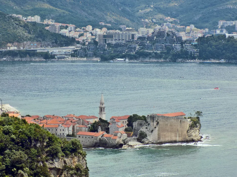 View from Mogren fortress toward Budva's old town on its peninsula and the modern skyline beyond