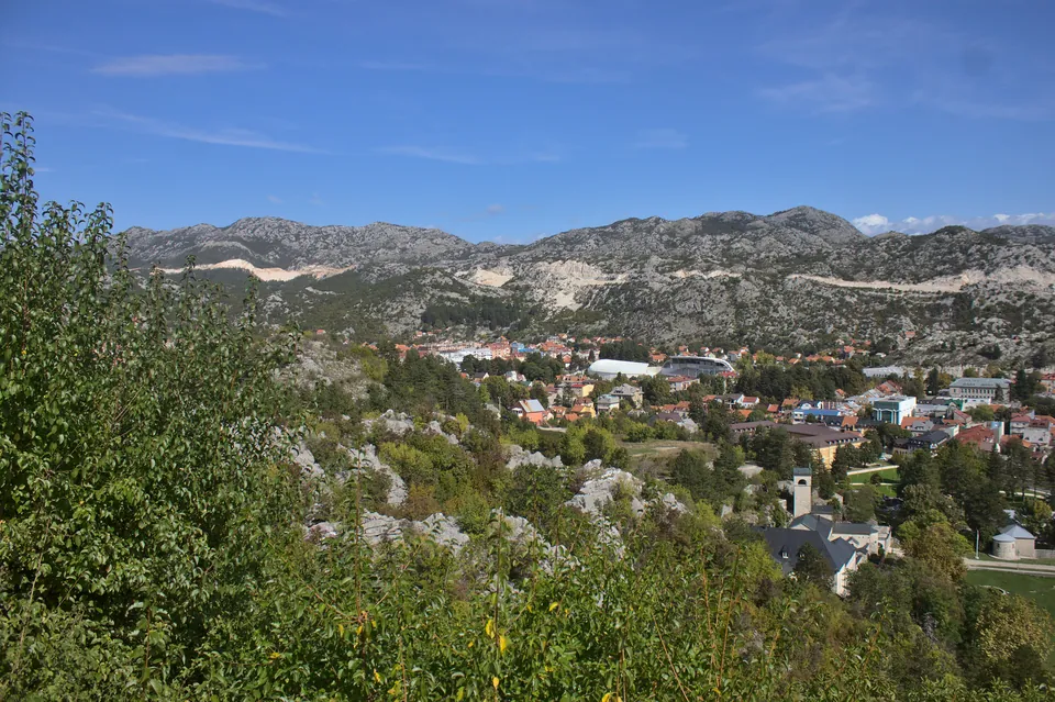 Cetinje seen from the Orlov krš viewpoint, rooftops among trees and bare limestone hills behind