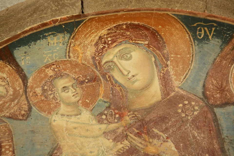 Close-up of a weathered medieval fresco depicting the Virgin and Child in Morača monastery