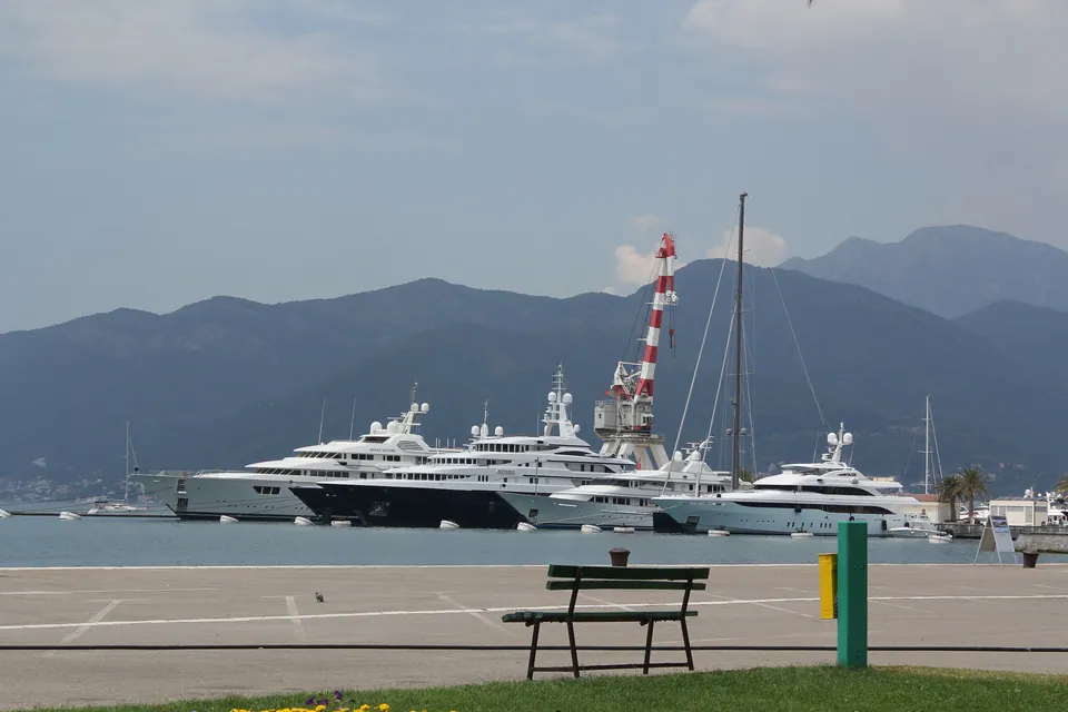 Superyachts berthed at Porto Montenegro in Tivat with the Vrmac ridge behind the marina