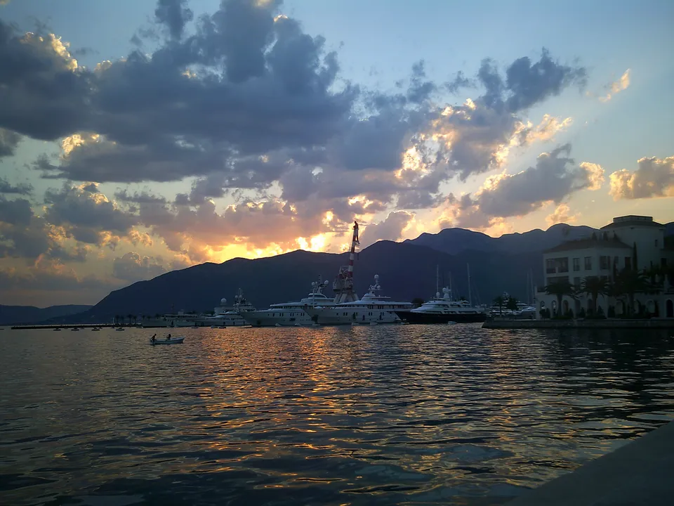 Yachts moored at Porto Montenegro marina in Tivat under a golden sunset sky