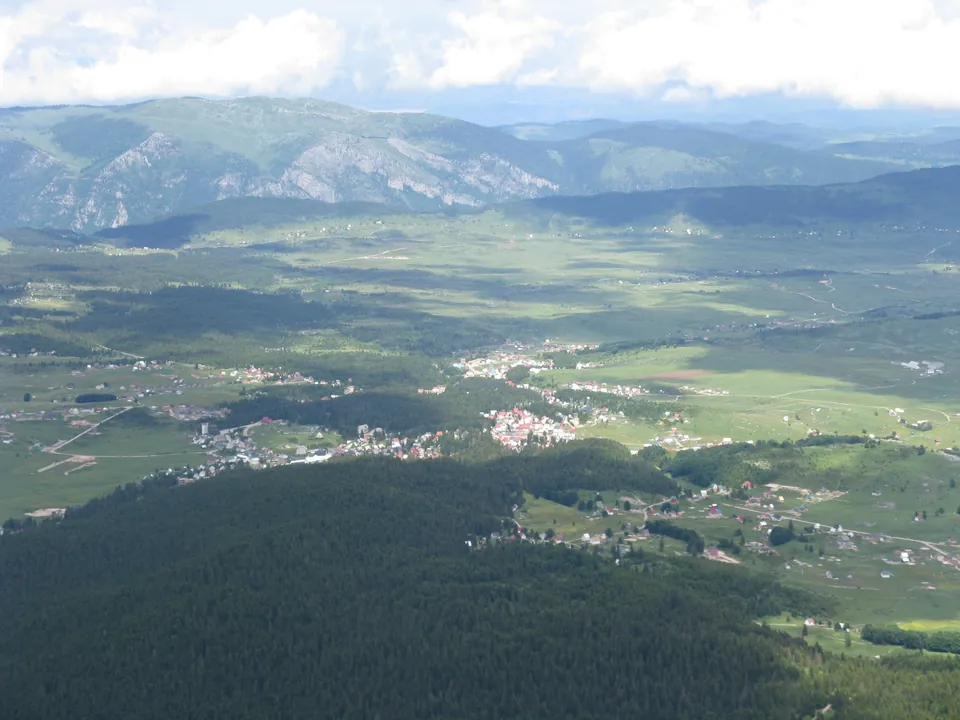 Aerial view of Žabljak town nestled in a green valley ringed by Durmitor peaks
