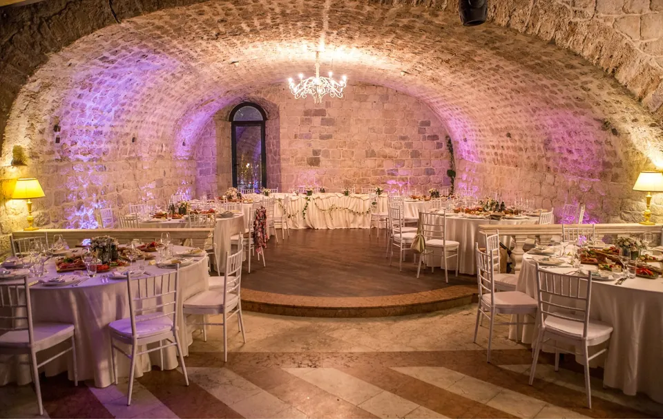 Stone vaulted hall set with round tables