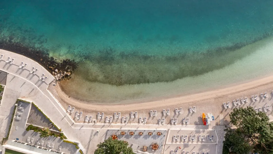 Beach and turquoise shallows seen from above