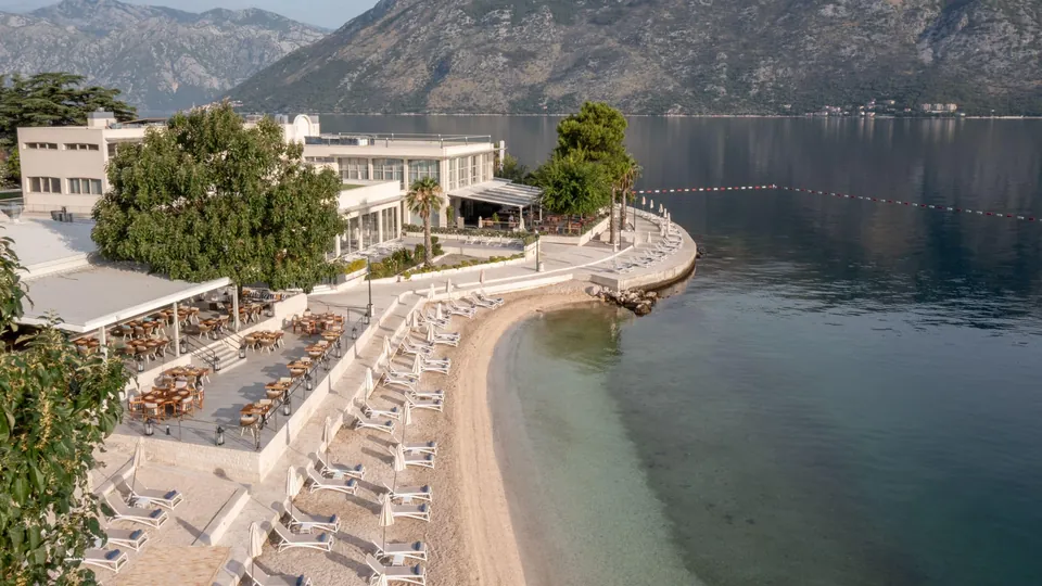 Curving beach with loungers and a waterside terrace